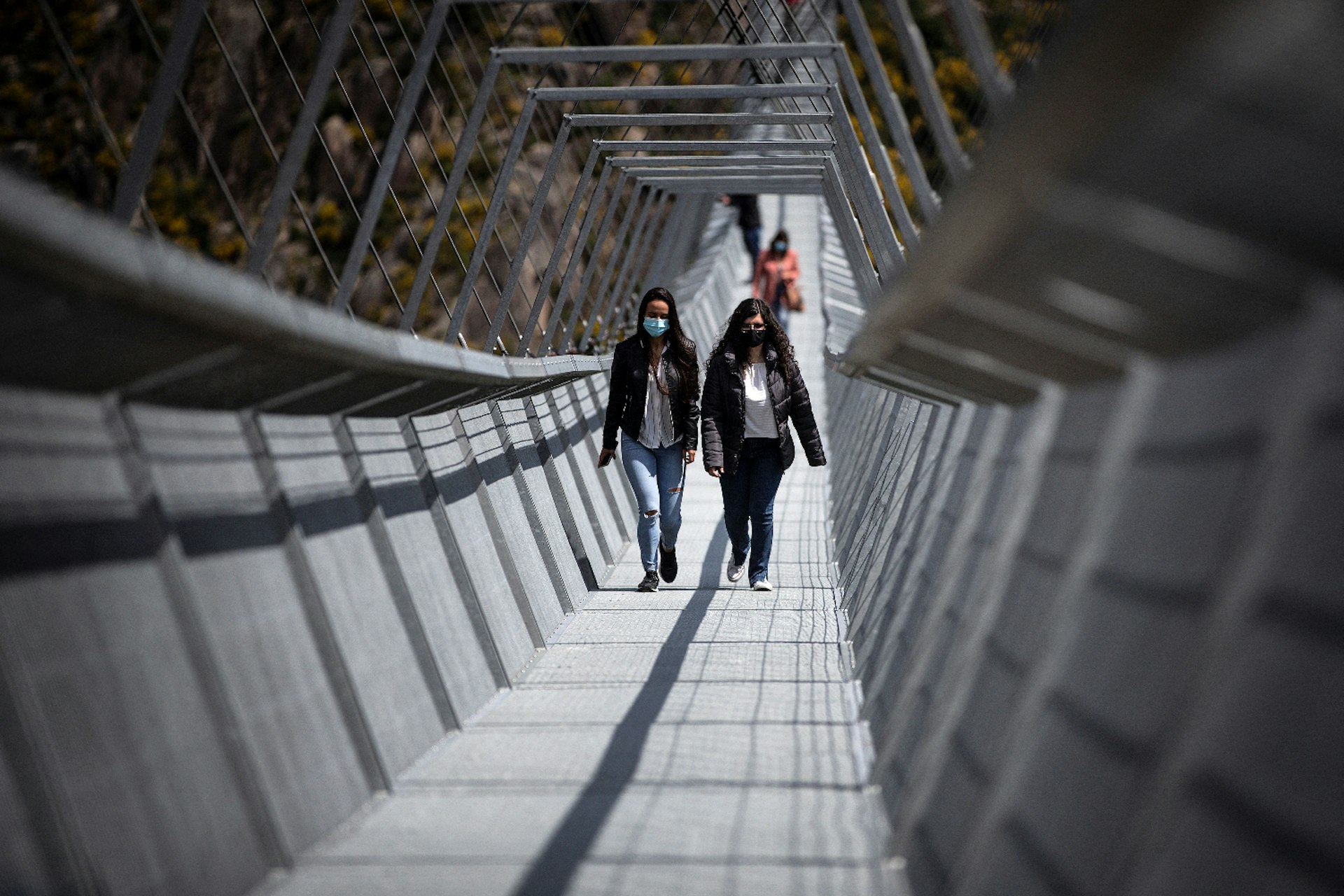 People wearing masks crossing the 516 Arouca Bridge in Portugal, the world's longest pedestrian suspension bridge